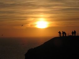group of photographers on a rock on the coast