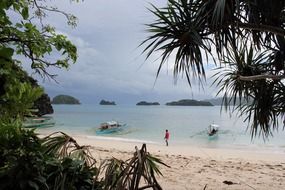 distant view of man on white sand at the beach