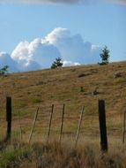 high cumulus clouds above the hill