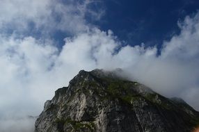 white cloud on a mountain peak on a sunny day