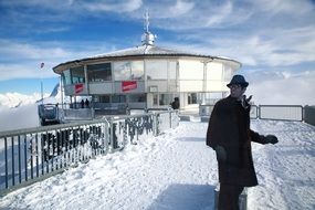 a man in a black coat on top of the mountain