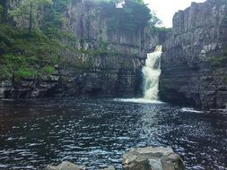 view from the river on the waterfall in the rocks