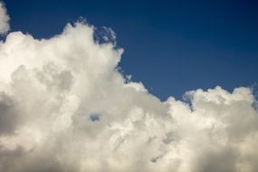 white cumulus clouds at deep blue sky