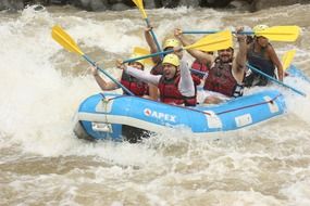 happy young people in raft on river