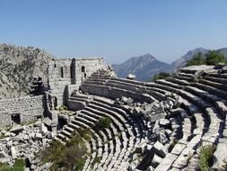 landscape of ruins of ancient theatre in mountains, turkey, antalya, termessos