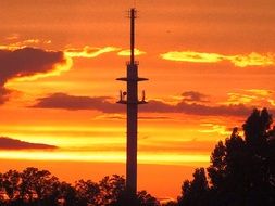 orange sky behind the transmission tower