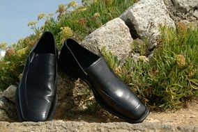 black mens wedding shoes on stones in nature