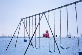 playground with swings in winter