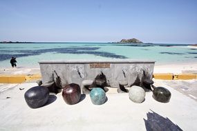 row of colorful stones at fountain in front of sea, korea