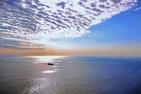 ship in sea under scenic clouds