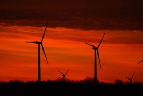 windmills against a bright orange sunset