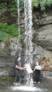 children play under a waterfall