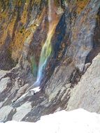 rainbow waterfall at glacier cliff, new zealand