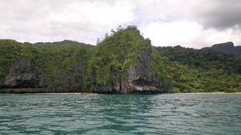 the rocks are covered with grass by the lake