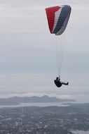 Paragliding flight with colorful parachute in Norway