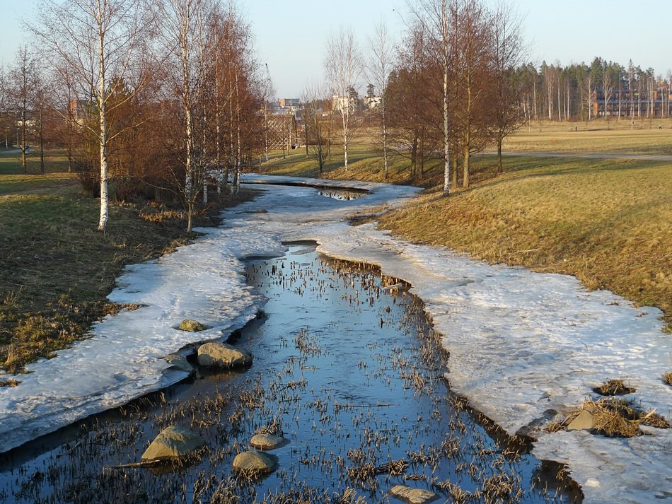 A stream with frozen shores in winter