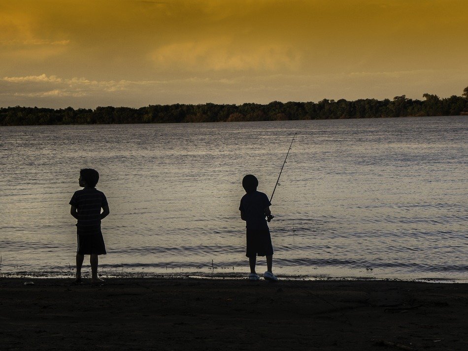 little fishermen on the river in the evening