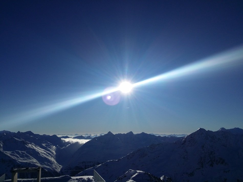 glare of the sun over the alpine mountain