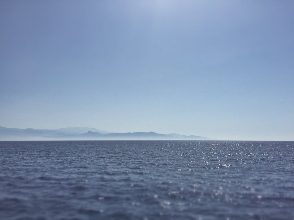 view from the water to an island with mountains