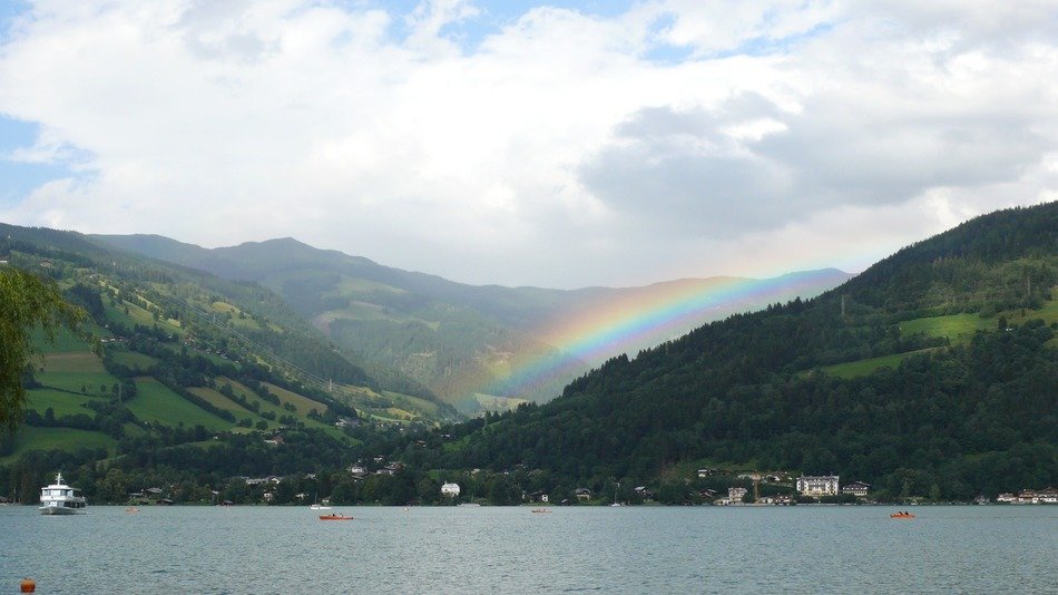 Rainbow over the lake near the green hills