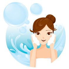 Young woman washing face with foam
