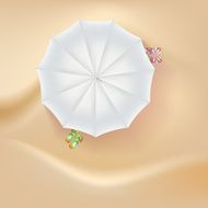 Beach slippers and a sun umbrella on sand background