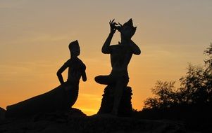 Silhouettes of sculptures under the sunset