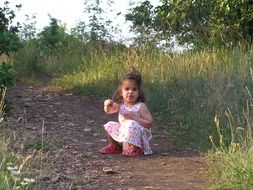 Little girl on the path near the grass