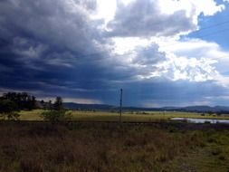 rain clouds above rural summer landscape