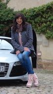 woman in jeans sittin on audi car