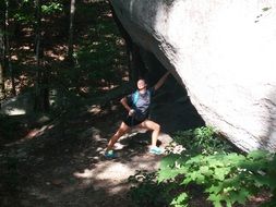 climber near a huge stone in the sunlight