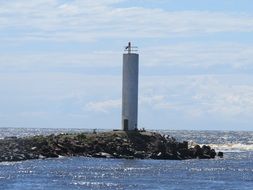 seascape with lighthouse on rocky beach