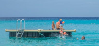 people on the platform in the ocean on the shore of the island of Curacao