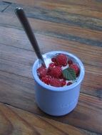 Yogurt with red fruit in a glass with a spoon