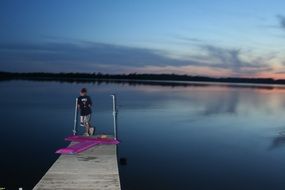 boy on a wooden pier in the evening