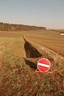 stop street sign at field before ditch