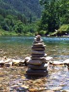 stone tower on a river in a mountain valley