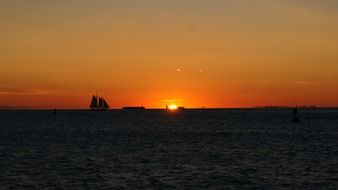 Beautiful and colorful sunset on horizon of water with the ship