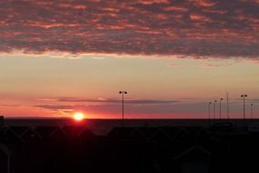 red rays of the sun above the horizon
