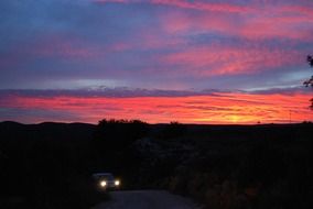 car headlights in the dark at sunset