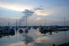 sailboats on the ocean water at dusk