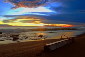 orange sunset in blue clouds over the beach