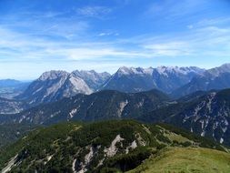 green Alps in Austria on blue sky background with white clouds