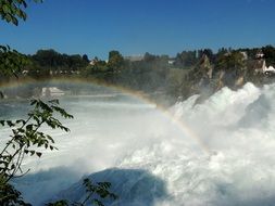 rainbow over a stormy waterfall, reinfall, switzerland
