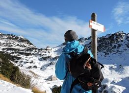 hiker with backpack near signpost in the mountains