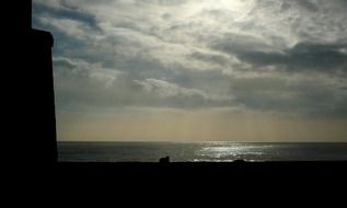 setting sun in dark thick clouds over the coast of spain