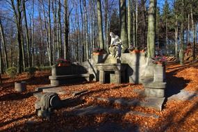 topless woman in crown, stone sculpture in forest at fall