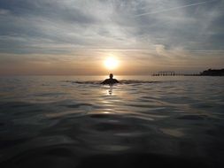 silhouette of a swimmer at sunset