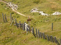 Broken wooden fence on a meadow