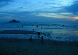 landscape of people on blue ocean coast at night